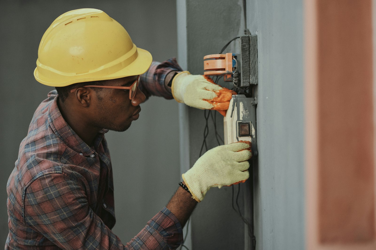 Licensed electrician working inside an open electrical panel with a screwdriver