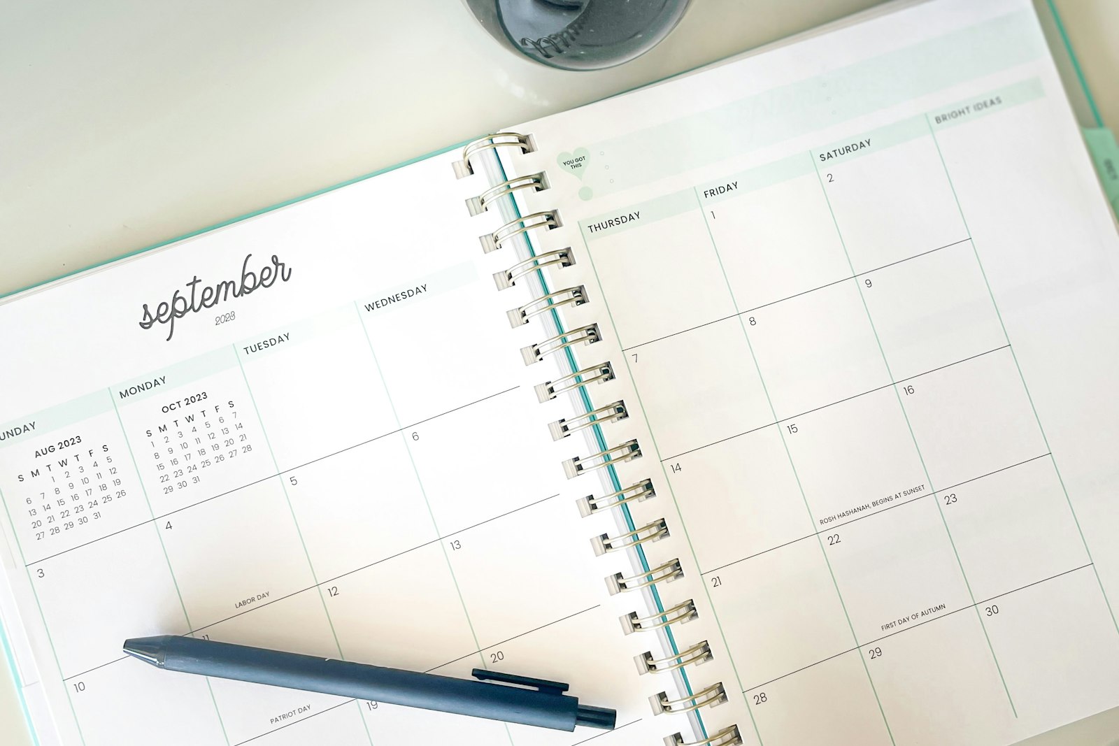 Open desk planner with a pen, hourglass and clock, representing a local SEO timeline