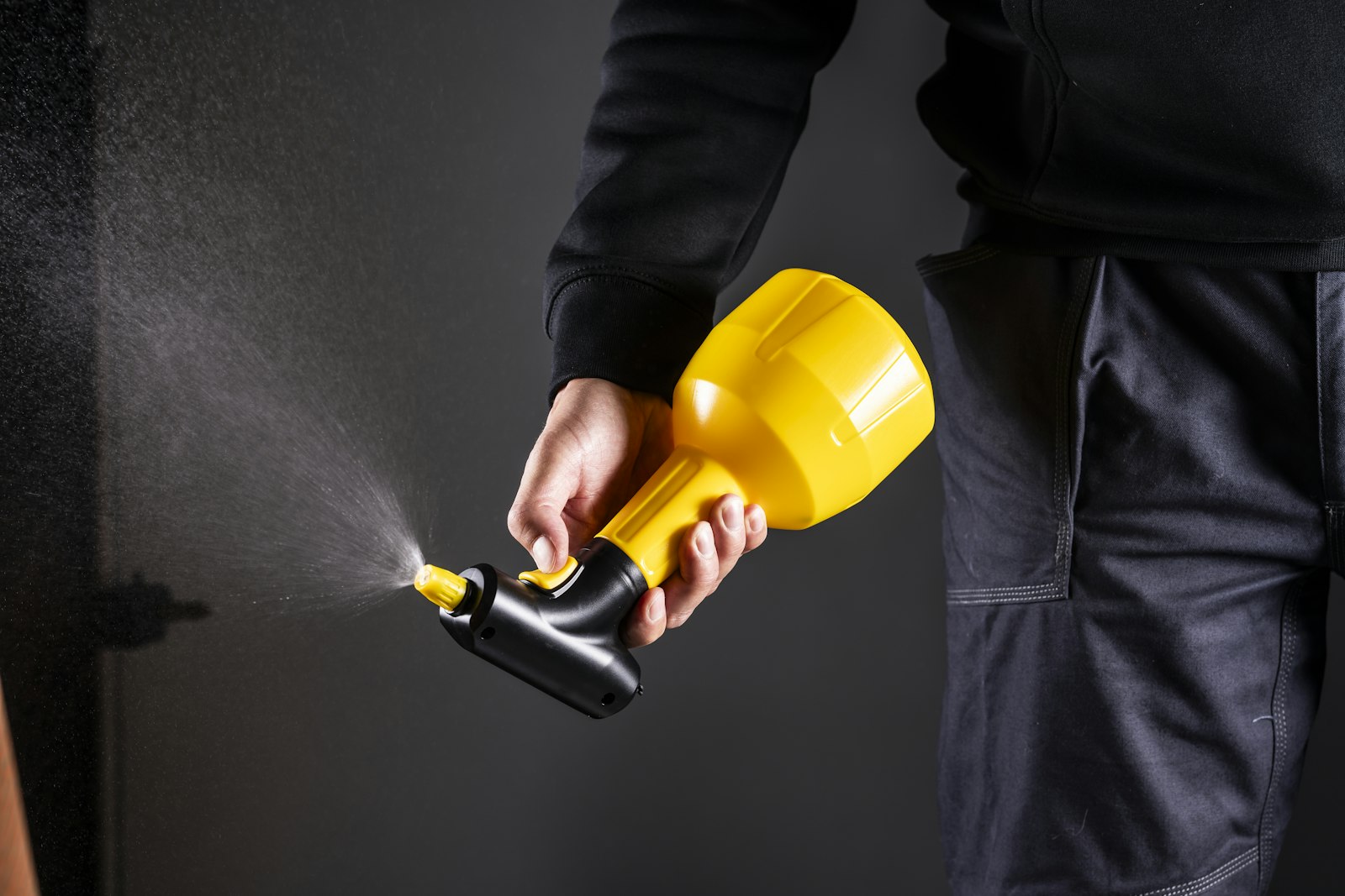 Pest control technician spraying treatment from a handheld sprayer
