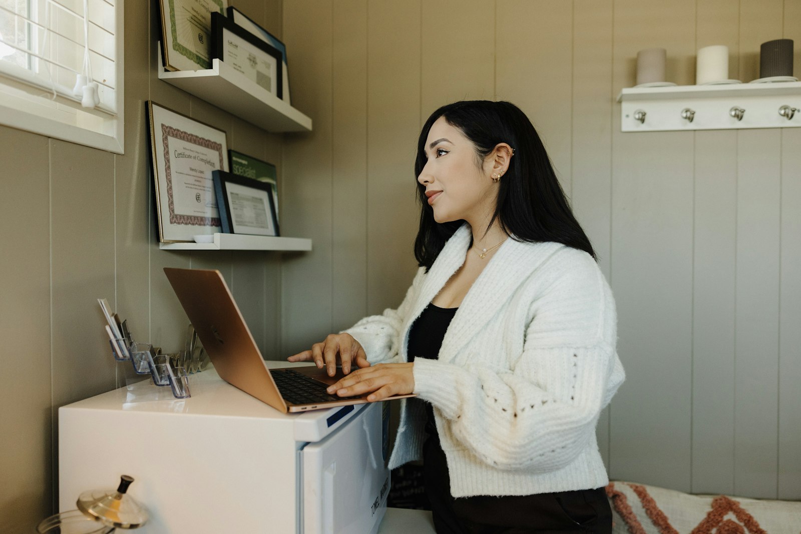 Small business owner reviewing her website on a laptop in a home office