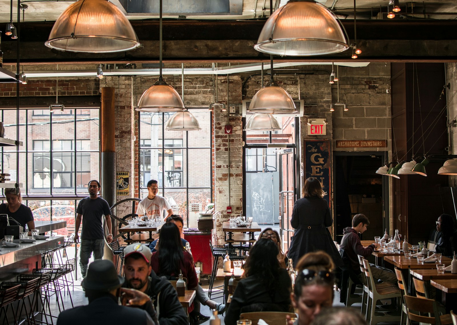 Guests dining at tables inside a warmly lit independent neighbourhood restaurant
