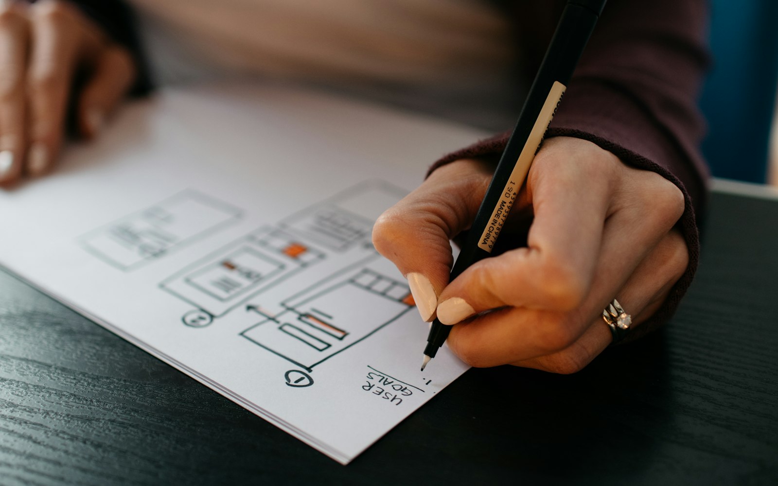 Designer sketching new homepage wireframes on paper while planning a small business website redesign