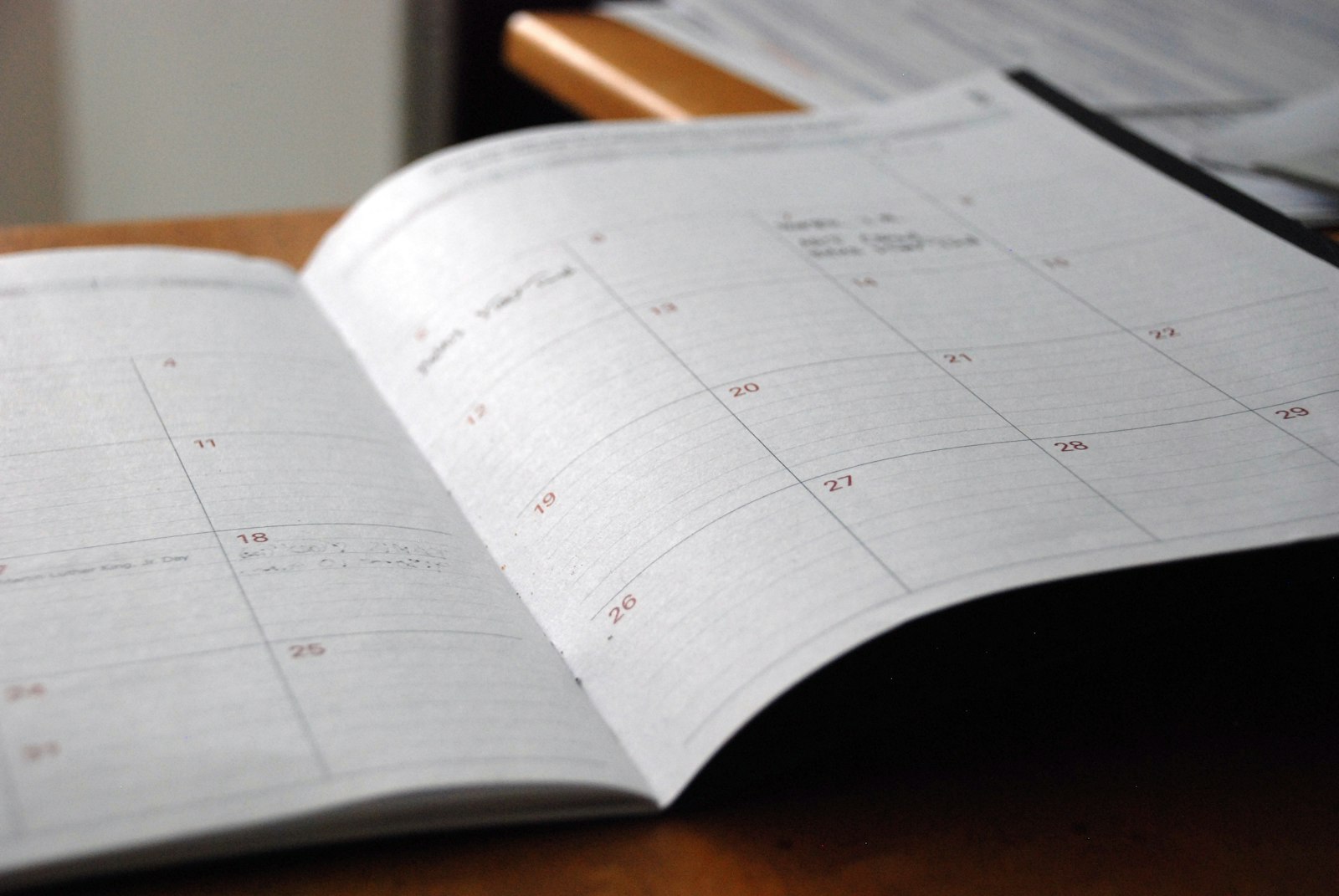 Web designer planning a website build timeline with a calendar and laptop at a desk