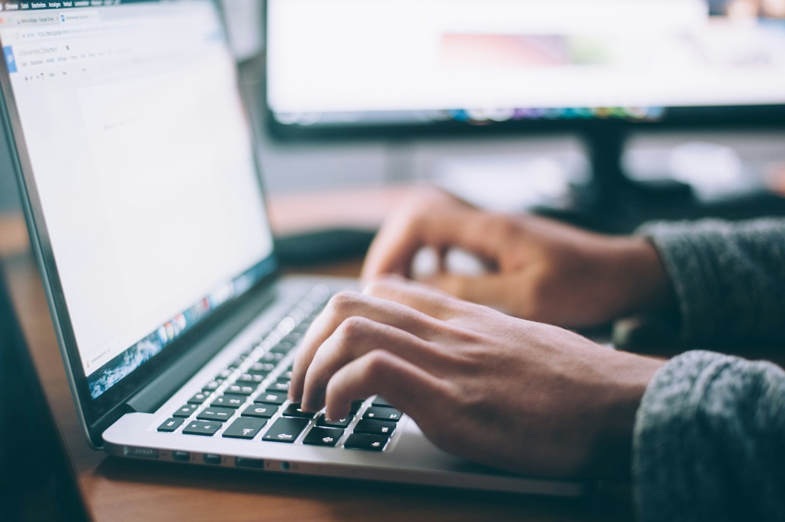 Small business owner comparing website builder options on a laptop at a desk